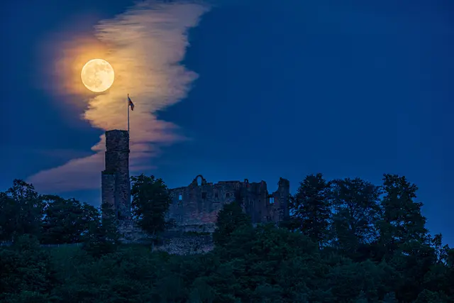 Ein leuchtender Vollmond über der Burg Hohenecken bei Kaiserslautern: Das Mondlicht spiegelt sich in den Wolken und taucht die Burgruine in geheimnisvolle Farben. | Foto: Harald Kröher