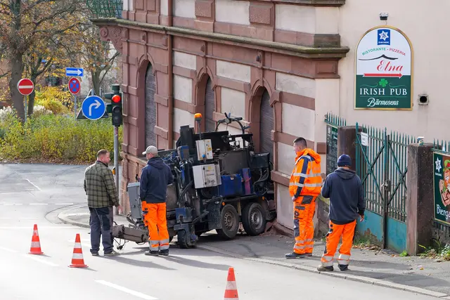 Arbeiter begutachten den Schaden: Eine Straßenmaschine war in der Volksgartenstraße ins Rollen geraten und prallte mit Wucht gegen die Fassade des Irish Pubs in Pirmasens.  | Foto: Erik Stegner