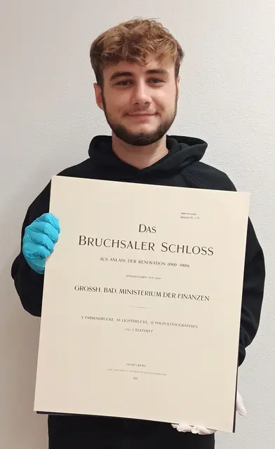 Praktikant Timo Stange mit dem Textteil der Hirsch-Mappe. | Foto: Städtisches Museum Bruchsal