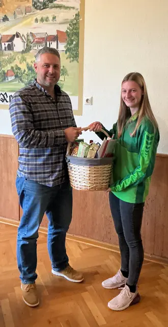 Lea Lißmann überreicht dem ehemaligen 1. Vorsitzenden einen Präsentkorb. | Foto: DLRG Kusel