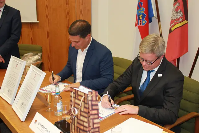Der offizielle Akt: Matko Burić (links) und Christian Hirsch setzen im Rathaus der Verbandsgemeinde Bruchmühlbach-Miesau ihre Unterschriften unter die Partnerschaftsurkunden. Die Zeremonie wurde von kommunalen Vertretern beider Gemeinden begleitet. | Foto: VG Bruchmühlbach-Miesau