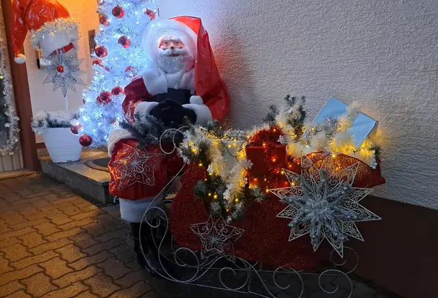 Die klassischen Weihnachtsfarben Rot und Weiß und viele Lichter dominieren die Dekoration neben der Eingangsstür | Foto: Monika Klein