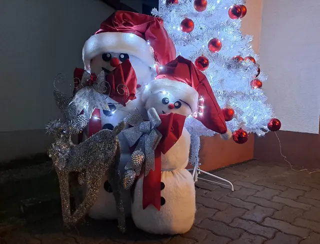 Neben der Garage: Die beiden Schneemänner tragen rote Nikolausmützen und silberne Schleifen | Foto: Monika Klein