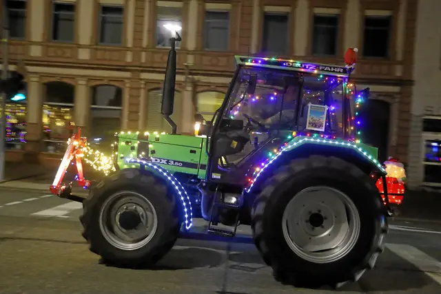 Ein festlich beleuchteter Traktor fährt am Freitagabend im Rahmen der Lichterfahrt durch die Innenstadt und sorgt vor der historischen Kulisse für weihnachtliche Stimmung. | Foto: Norbert Scharf