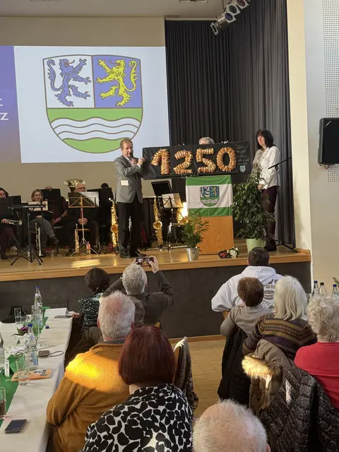 1250 Jahre Alsenz, Stadtbürgermeister Michael Vettermann mit Beig. Michaela Schwind-Grimm (hinter der Backwerkzahl) überreicht OB Karin Wänke (rechts) sein mit "viel Liebe" gebackenes 1250er-Geschenk - und dies trotz eigener sehr enger Kassen, so Vettermann  | Foto: Arno Mohr 