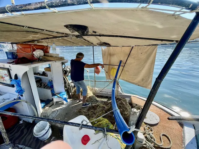 An der Hafenmole von Argostoli bereitet ein Fischer sein Boot für den nächsten Fang vor – zwischen Netzen, Leinen und dem ruhigen Wasser vollzieht sich jene stille Routine, die das Leben am Meer seit Jahrhunderten prägt. In dieser Szene aus der kleinen Inselhauptstadt verdichtet sich eine Form des Arbeitens, die nicht gegen die Natur gerichtet ist, sondern ihren Rhythmen folgt: geduldig, aufmerksam und durch tägliche Wiederholung tief mit dem Element verbunden.
 | Foto: Daniel J. Basler