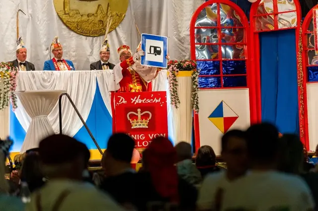 Ein Büttenredner persiflierte 2025 in Ludwigshafen die Meckerer-Kultur, die zurückblickt und glaubt, früher sei alles besser gewesen. Narren treten bis heute im närrischen Adelskostüm auf. Dahinter sitzen die Minister im Prunkkostüm.  | Foto: Kim Rileit