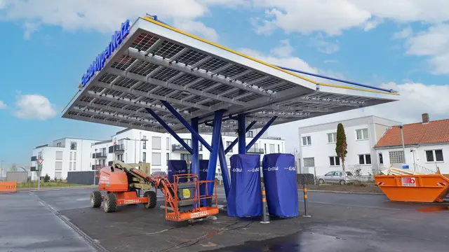 Hebebühnen und Arbeitsgeräte stehen noch unter dem Solardach: Der neue EnBW-Schnellladepark in Landstuhl ist klar erkennbar, die Technik wird derzeit installiert. | Foto: Erik Stegner