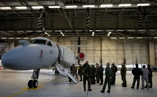 Eine EA-37B „Compass Call“ in einer Halle auf der Air Base Ramstein. Militärangehörige begutachten das Spezialflugzeug für elektronische Kriegsführung, das nun erstmals in Ramstein Station gemacht hat. | Foto: Edgar Grimaldo
