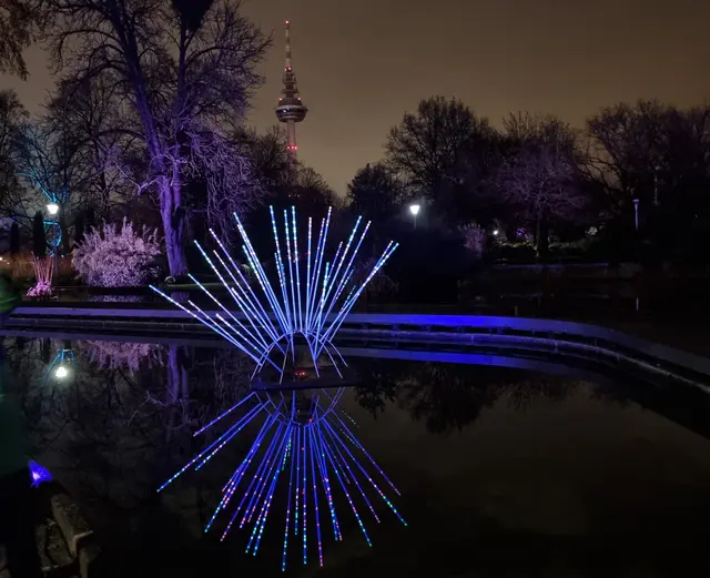 Leuchtstäbe spiegeln sich im Wasser - im Hintergrund der Mannheimer Fernsehturm. | Foto: BAS