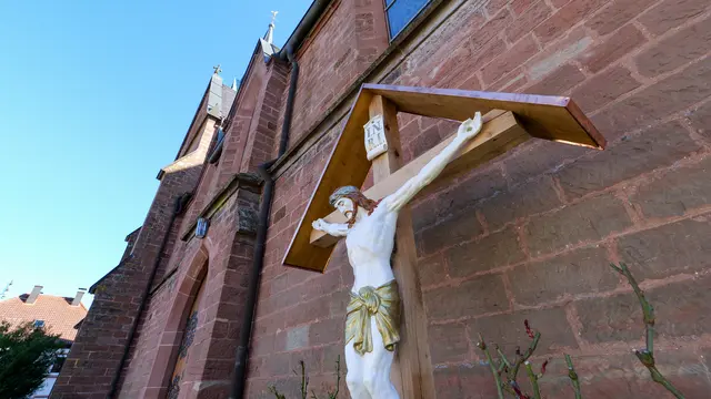 Vor der St.-Valentinuskirche in Bann erhebt sich das restaurierte Missionskreuz wieder sichtbar über dem Kirchplatz. Die Gemeinde reagierte auf die Tat vom Juli 2025 mit Wiederaufbau und Zusammenhalt. | Foto: Erik Stegner
