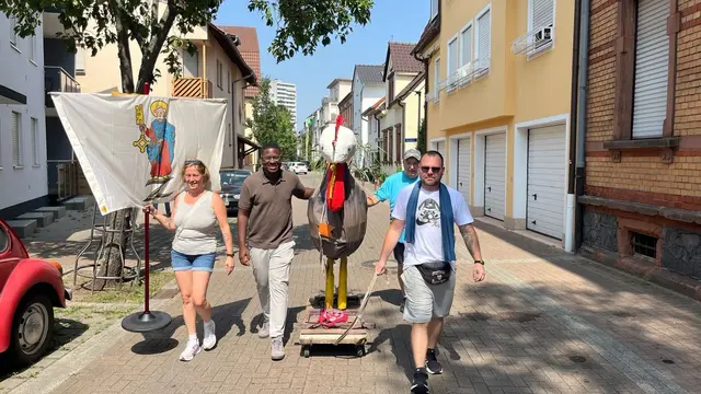 Unterwegs mit dem Gockel durch Mundenheim. Der mannshohe Gockel wird zum Kerweplatz gebracht.  | Foto: Interessengemeinschaft Mundenheimer Kerwe