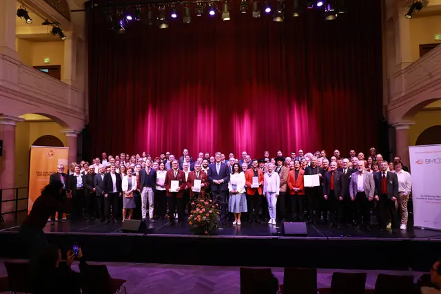 Auf der Festkonzert-Bühne der Fruchthalle Kaiserslautern:  die ausgezeichneten Ensembles, Vertreter*innen weiterer Plaketten-Empfänger 2026 sowie Vertreter*innen von Verbänden und Organisationen der Amatermusik in Deutschland sowie Bundesverkehrsminister Patrick Schnieder  | Foto: Rolando de Sousa/gratis