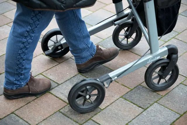 So geht's richtig: Die Füße befinden sich zwischen den Hinterrädern. Heißt: man geht nicht hinter, sondern im Rollator sicher.  | Foto: dpa