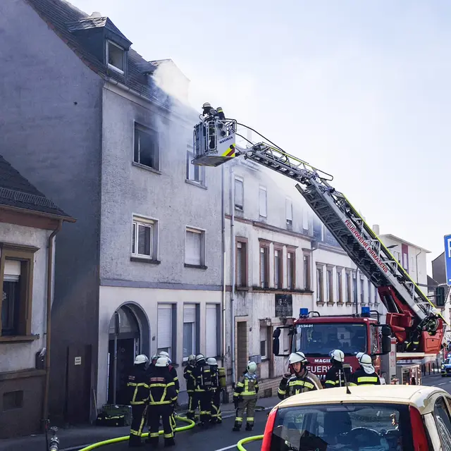 Feuerwehreinsatz in der Rodalber Straße in Pirmasens: Über die Drehleiter gehen Einsatzkräfte gegen den Brand im oberen Geschoss vor, während dichter Rauch aus den Fenstern dringt und weitere Trupps das Gebäude sichern. | Foto: Erik Stegner