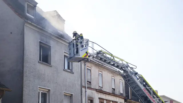 Feuerwehrleute im Einsatz über der Rodalber Straße in Pirmasens: Über die Drehleiter erreichen die Einsatzkräfte das betroffene Obergeschoss, aus dem dichter Rauch austritt. | Foto: Erik Stegner