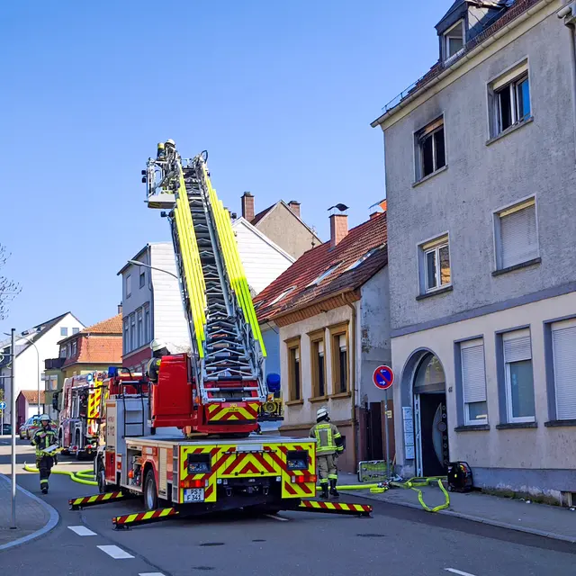Feuerwehreinsatz in der Rodalber Straße in Pirmasens: Die Drehleiter wird in Stellung gebracht, während Einsatzkräfte das Mehrfamilienhaus sichern und die Brandbekämpfung vorbereiten. | Foto: Erik Stegner