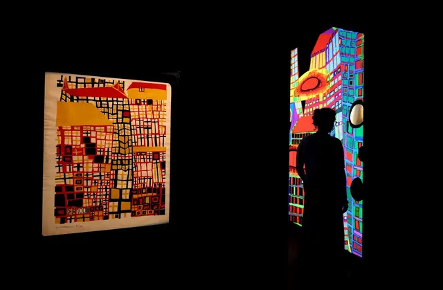 Hundertwasser ist bekannt für bunte Farben wie im Linolschnitt "Drei hohe Häuser". | Foto: dpa