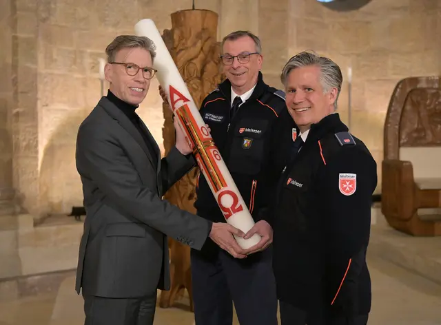 V.l.n.r.: Domkapitular Peter Schappert, Matthias Geist, stellvertretender Diözesanleiter, und Prof. Dr. Christopher Wolf, Diözesanleiter des Malteser Hilfsdienstes, bei der Übergabe der Osterkerze 2026 im Speyerer Dom | Foto: Domkapitel Speyer/Klaus Landry