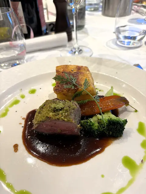 Rosa gebratene Hüfte vom Salzwiesenlamm, karamellisierte Karotten, wilder Brokkoli, Kartoffelgratin, Salbeisauce. | Foto: Volker Widdrat