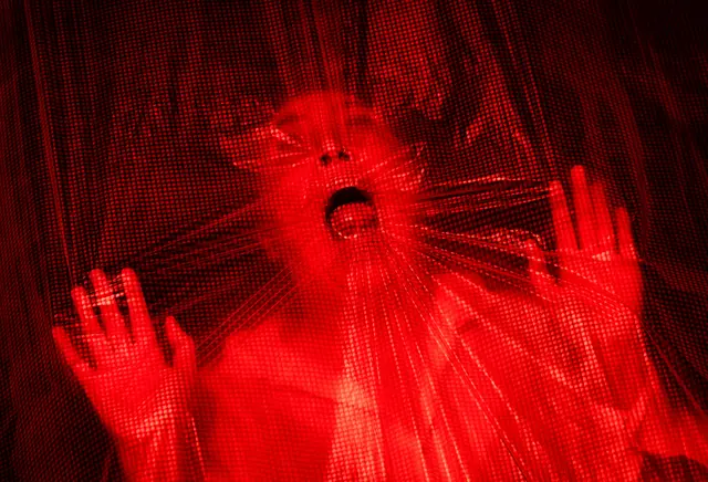 Eine schreiende Person drückt ihr Gesicht gegen eine Folie | Foto: Christian Kleiner