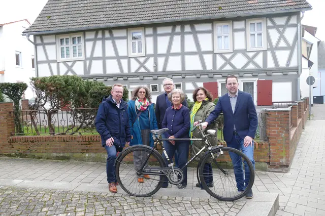 Symbol für jahrzehntelangen Einsatz: Das Fahrrad von Dr. Benedikt Kienle wurde auf dem Kienle-Platz an das Museum übergeben. Im Hintergrund das Kienle-Haus. 
Von links: Bürgermeister Matthias Baaß, Museumsleiterin Elke Leinenweber, Dr. Clemens Schopp, Claudia Schopp, Dr. Cornelia Schopp und Erster Stadtrat Jörg Scheidel. | Foto: Stadt Viernheim/Stadtarchiv Viernheim