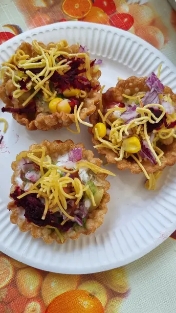 "Basket Chaat": Die Schale besteht aus Weizenmehl, wird (in diesem Fall) mit fein gehacktem Gemüse, Bohnen, süßem Quark und Gewürzen gefüllt, garniert mit grünem Koriander und rotem Tamarinde-Chutney. | Foto: IGNKA