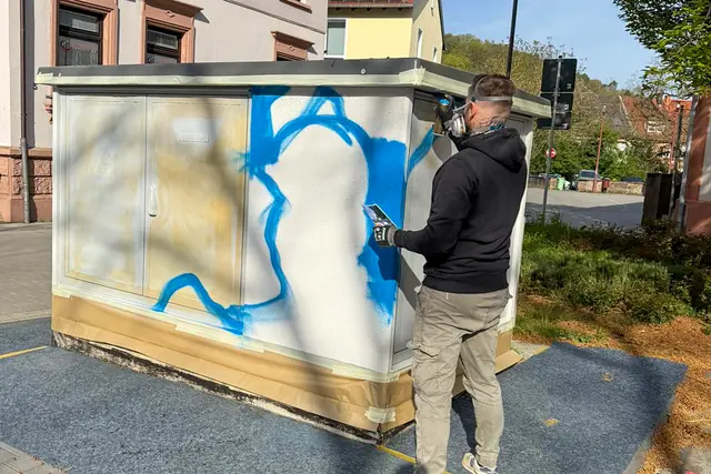 Die ersten Konturen entstehen: Daniel Ferino legt an der Trafostation am Adolph-Kolping-Platz die Grundformen für das spätere Kunstwerk an. | Foto: Stadt Landstuhl