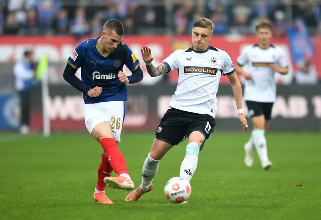 Kaiserslauterns Norman Bassette (r) stört den Kieler Torschützen David Zec. | Foto: Daniel Bockwoldt/dpa
