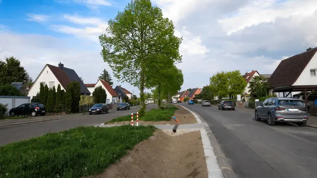 Das Wasser fließt bei Starkregen in die Versickerungsmulde ab. Die Straße hat an Breite verloren, für Parkraum und Fahrbahn ist noch genug Platz.  | Foto: Julia Glöckner