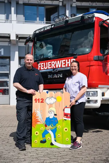 Mathias Schmitt (links) übergibt seine Arbeit an Sarah Maugeri vom Nils-Projekt | Foto: Feuerwehr KL/gratis