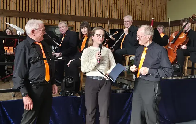 Ehrung für 70 Jahre aktiven Musizierens. Lisa Gaß vom Musikkreis Donnersberg mit der Urkunde für Günter Wilding (links). Wolfgang Scherr assistiert. | Foto: Carina Haag