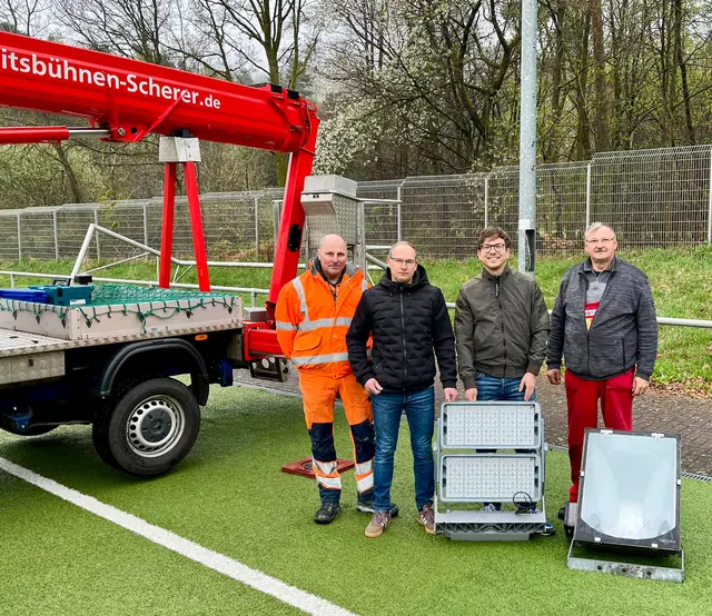 Neue Technik im Fokus: Vertreter der Stadt und beteiligte Fachleute präsentieren am Kunstrasenplatz im Stadion Rothenborn die ausgebauten Leuchten sowie die neue LED-Flutlichtanlage. | Foto: Stadt Landstuhl