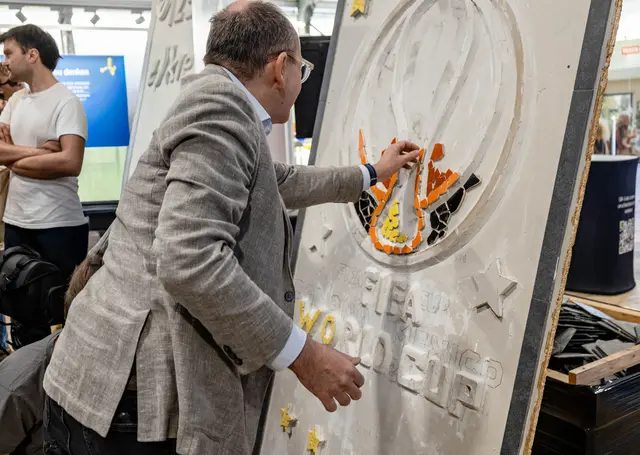 Christian Specht bewundert die Mosaikarbeit und versucht es selbst   | Foto: Wolfgang Neuberth