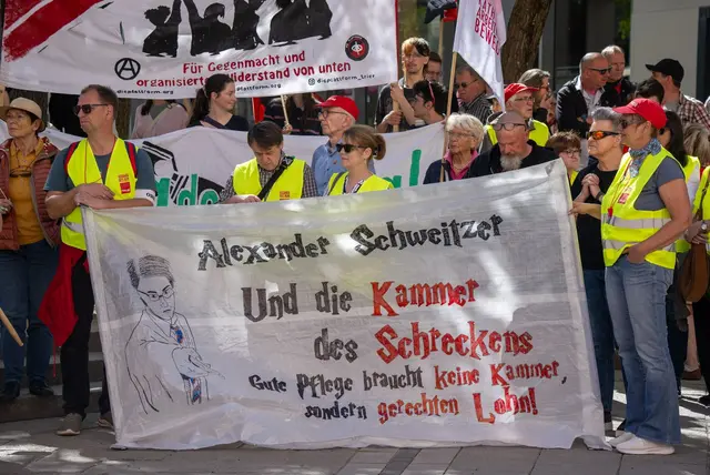 Gerechten Lohn in der Pflege fordern diese Demonstranten bei der zentralen DGB-Kundgebung in Trier und richten sich an den rheinland-pfälzischen Noch-Ministerpräsidenten Alexander Schweitzer (SPD). | Foto: Harald Tittel/dpa