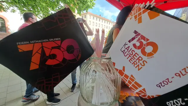 Zum Mitnehmen: Vor der Tourist Information ist ein Stand mit den Jubiläumsfähnchen aufgebaut | Foto: Monika Klein