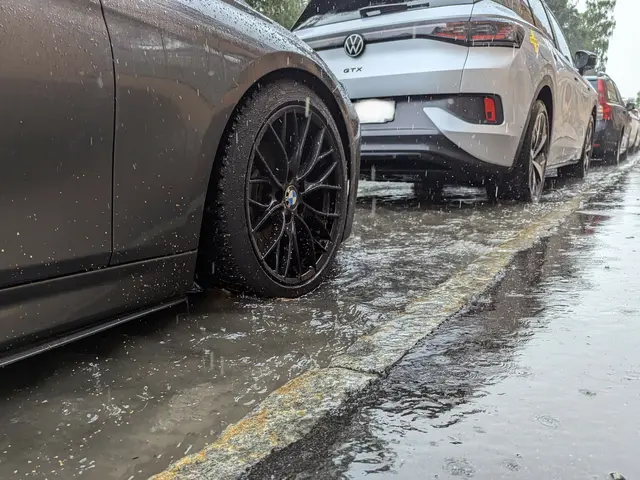 Das Bild zeigt eine überflutete Straße mit fahrenden Autos