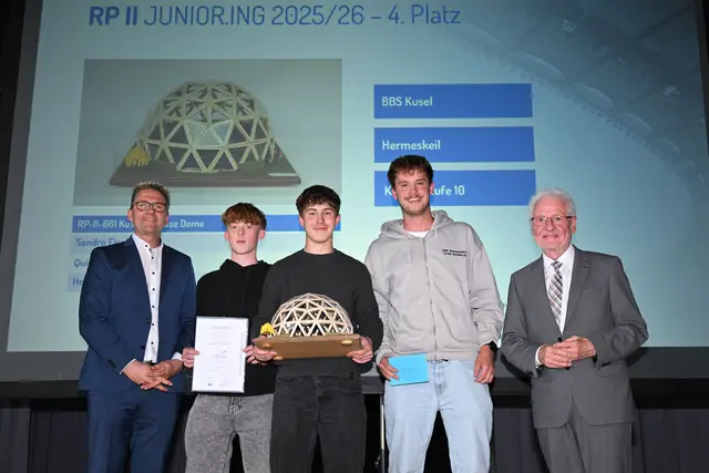 Kammerpräsident Dr. Horst Lenz (l.) und Volker Tschiedel, Bildungsministerium Rheinland-Pfalz (r.) beglückwünschten Sandro Eisele, Quinten Frey und Hennes Späth mit dem Arena-Dach Modell „Kuseler Messe Dome“ zum 4. Platz in der Altersklasse II. | Foto: Kristina Schäfer