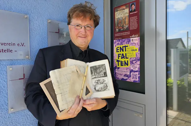 Michael Landgraf vor dem Bibelmuseum mit Schreibmaterialien und dem Plakat der Reihe ENTFALTEN | Foto: Michael Landgraf