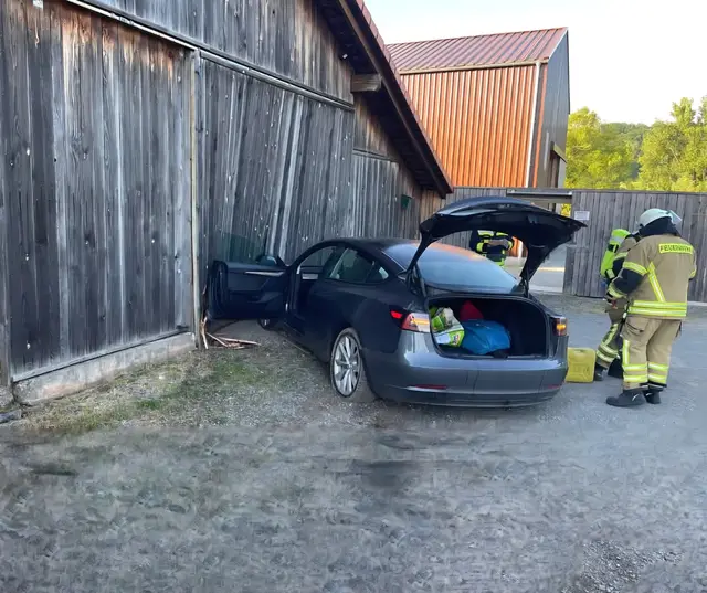Das Elektroauto überfuhr einen Kreisverkehr und prallte anschließend gegen das Tor einer Scheune. | Foto: Freiwillige Feuerwehr VG Otterbach-Otterberg
