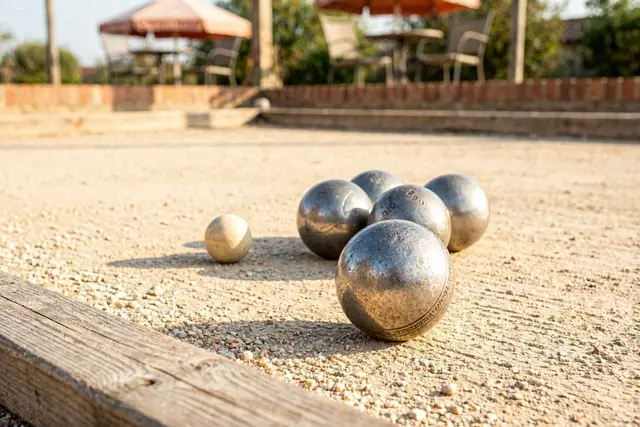 Das Bild zeigt Boulekugeln auf einem Spielfeld