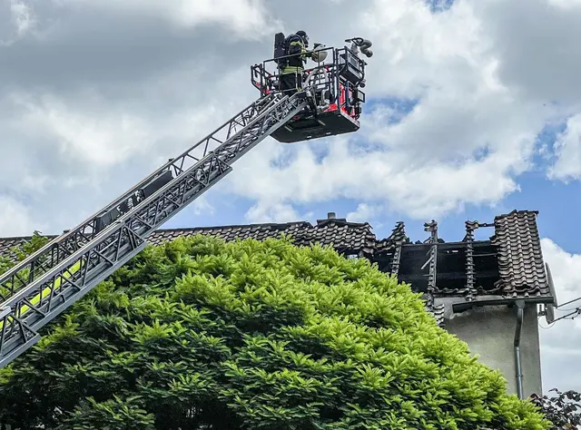 Die Löscharbeiten der Feuerwehr am Dachstuhl laufen.  | Foto: Jason Tschepljakow/dpa