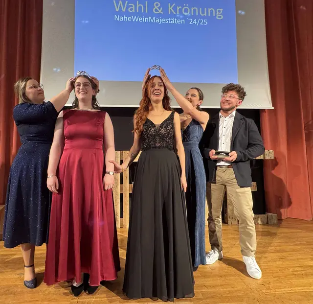 Wahl der letzten Naheweinmajestäten 2024/2025, links Naheweinprinzessin Laura Ludwig im roten Kleid, rechts die Naheweinkönigin Zoe Keller de Almeida im schwarzen Kleid, 
dahinter die Naheweinmajestäten 2023/2024, erstmals dabei auch ein männlicher Naheweinprinz -Tim Heck, ganz rechts  | Foto: Arno Mohr 