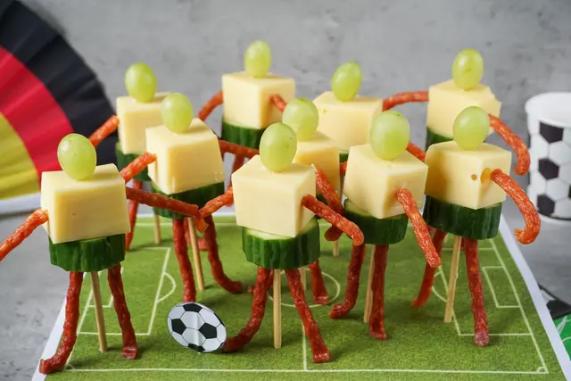 Käse-Trauben-Spieße im Fußballer-Look drängeln sich auf dem Spielfeld von Bloggerin Jenny Böhme.  (zu dpa: «Mini-Kicker zum Wegputzen - auf dem Platz vor dem TV») | Foto: dpa