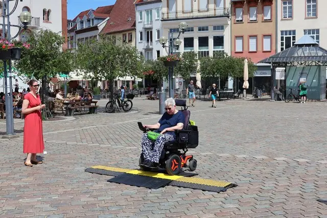 Bei Veranstaltungen helfen neue Kabelbrücken auf dem Rathausplatz, sicher über Leitungen zu kommen.Gertrud Gerdon vom Kommunalen Beirat für die Teilhabe von Menschen mit Behinderungen in Landau probiert die neuen barrierefreien Kabelbrücken aus.  | Foto: Stadt Landau