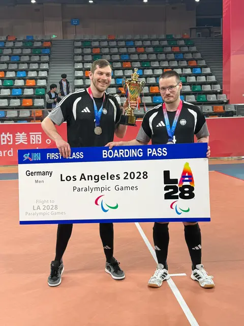 Die BSS-Spieler Daniel Arendar (links) und Philipp Tauscher (rechts) präsentieren nach dem Gewinn der Silbermedaille bei der Goalball-Weltmeisterschaft das symbolische Ticket zu den Paralympischen Spielen 2028 in Los Angeles. | Foto: Stefan Weil