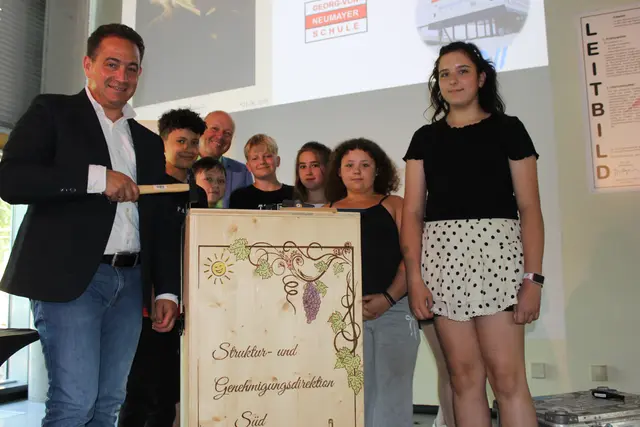 Mit im Gepäck hatte Präsident Hannes Kopf (links) eine XXL-Weinkiste. Diese steht symbolisch für die seit 1984 bestehende Patenschaft der SGD Süd beziehungsweise der ehemaligen Bezirksregierung Rheinhessen-Pfalz mit der deutschen Forschungsstation Neumayer III in der Antarktis. | Foto: SGD Süd/gratis