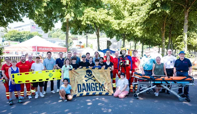 Zum Abschluss des Wasserrettungstags an der Saar versammeln sich Schülerinnen und Schüler der Klassenstufen 7 und 9 gemeinsam mit Vertretern von DLRG, Johannitern, Berufsfeuerwehr, Politik und weiteren Partnern zum Gruppenfoto. | Foto: Laszlo Pinter/dpa