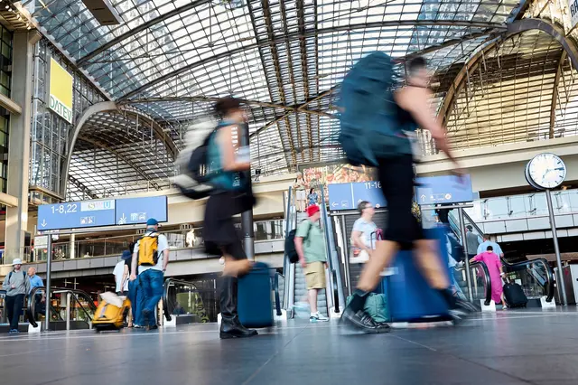 Mit Kaffee oder Koffer in der Hand geht es in Berlin am Morgen entspannt zu. | Foto: Michael Ukas/dpa