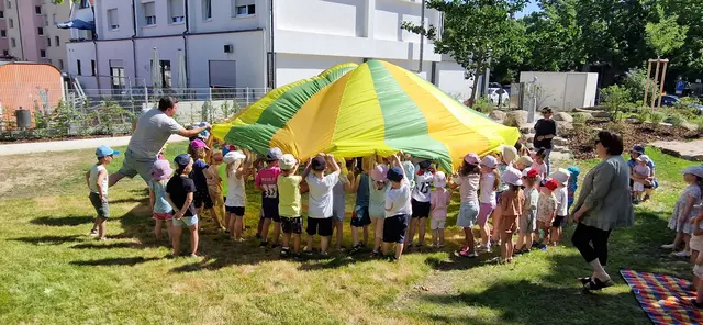 Auf ein lautes „Eins-Zwei-Drei“ lüfteten alle Kinder gemeinsam den bunten Fallschirm, der vorher geheimnisvoll die neuen Spielgeräte verdeckt hatte | Foto: Elke Döngi/Friedrich-Fröbel-Kita Göllheim/gratis